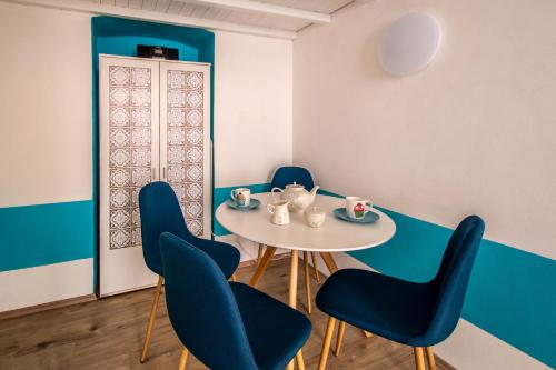 a dining room with a white table and blue chairs at Sweet Home by Ruterra in Prague