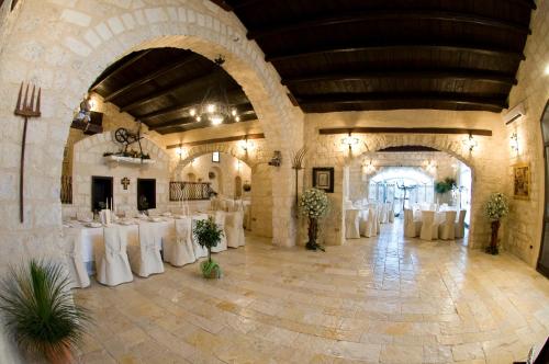 a banquet hall with white tables and white chairs at Le Querce di Mamre in Manfredonia