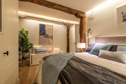 een slaapkamer met een groot bed en een stoel bij New Soho AC by Staynnapartments in Bilbao