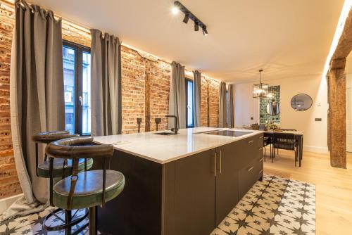 een keuken met een wastafel en een aanrecht met krukken bij New Soho AC by Staynnapartments in Bilbao