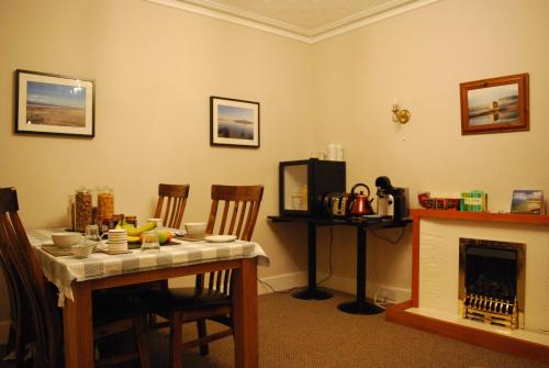 a dining room with a table and a fireplace at Doric House in Inverness