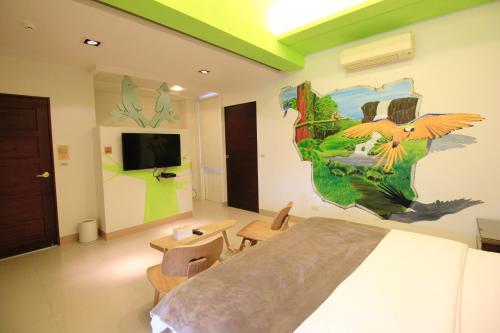 a bedroom with a bed and a painting on the wall at Green Park Homestay in Luodong