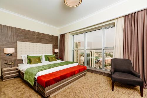 a bedroom with a bed and a chair and a window at Grand Pasha Lefkosa Hotel & Casino in North Nicosia