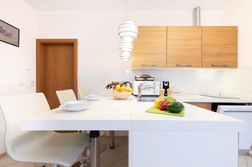 a kitchen with a white counter with fruit on it at Apartments Pri nas in Kobarid