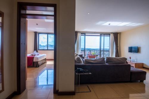 a living room with a couch and a bedroom at Bukoto Heights Apartments in Kampala