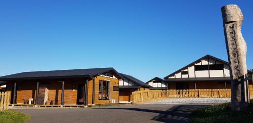 a building with a totem pole in front of it at Tsushima Izuhara Pension in Tsushima