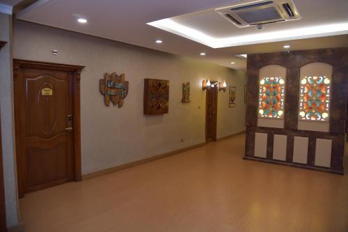 a hallway with a door and stained glass windows at Parezh Hotel in As Sulaymānīyah