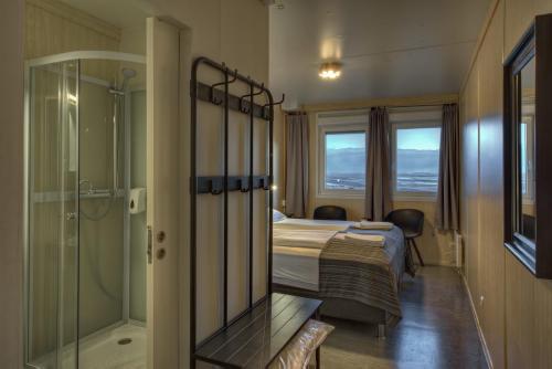 a hotel room with a bed and a shower at Vikingcafe in Höfn