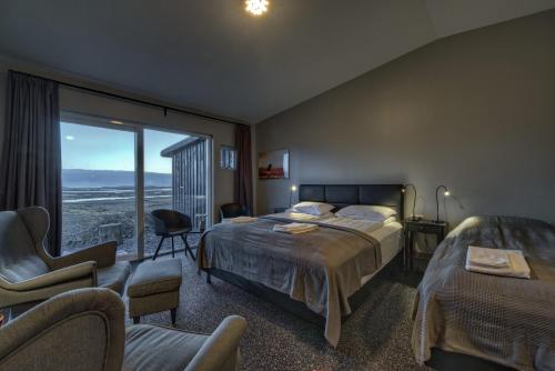 una camera d'albergo con un letto e una grande finestra di Vikingcafe a Höfn