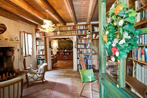 una biblioteca con estanterías de libros y una lámpara de araña en Regina Sconta, en Villa Estense