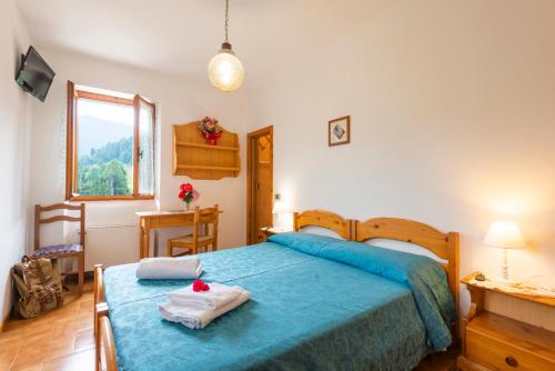 Rifugio Monte Baldo في أفيو: غرفة نوم عليها سرير وفوط