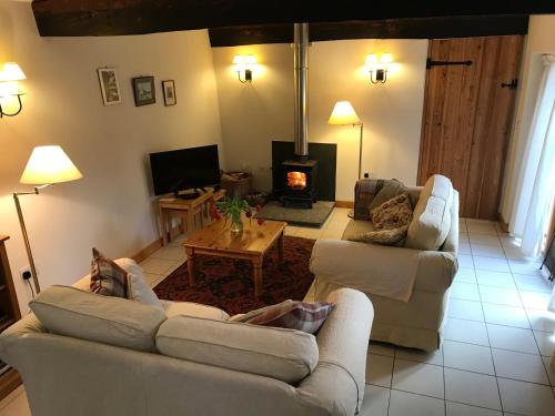 a living room with two couches and a fireplace at The Old Coach House in Pen-pergwm