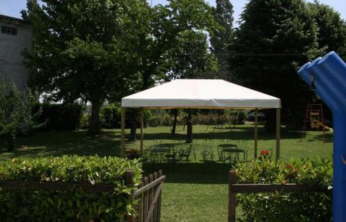 a white gazebo with chairs and tables in a yard at Hotel De La Ville in Bereguardo