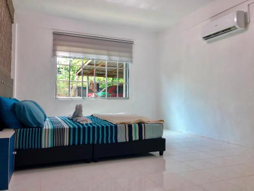 een slaapkamer met een bed en een raam bij Padang Besar Twin Homestay in Padang Besar