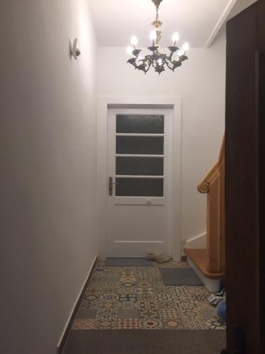 a hallway with a door and a chandelier at Lieblingsnest Detmold in Detmold