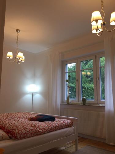 a bedroom with a bed with a lamp and two windows at Lieblingsnest Detmold in Detmold