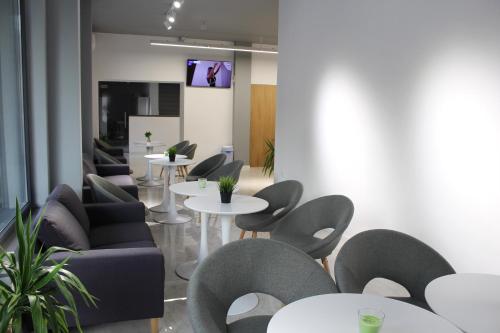 a waiting room with tables and chairs and a tv at Hotel39 in Plovdiv