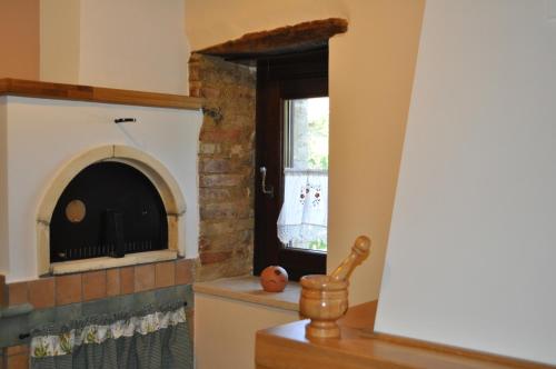 CrecchioにあるZà Marietteのキッチン(レンガ造りの暖炉、窓付)