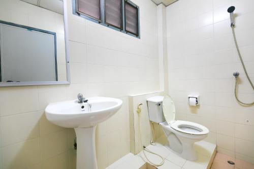 a white bathroom with a sink and a toilet at Tokyo Hotel in Ubon Ratchathani