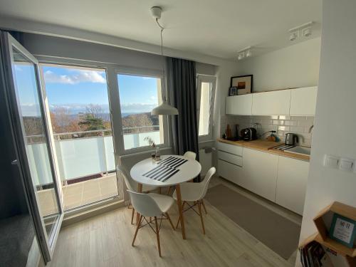 a kitchen with a table and chairs in a room at Apartament Horizon in Gdynia