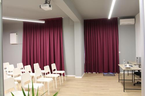 a conference room with red curtains and white chairs at Hotel39 in Plovdiv