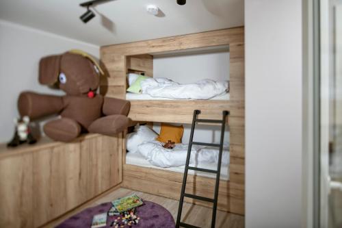 a room with two bunk beds with a teddy bear at Berg und Tal Hotel & Apartments in Braunlage