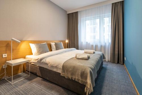 a bedroom with a large bed and a window at Cotton House in Łódź