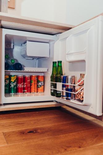 an open refrigerator filled with drinks and soda cans at Pensiunea Casa Hortopan in Târgu Jiu