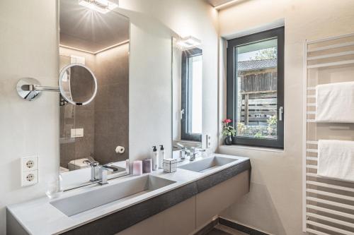 a bathroom with two sinks and a mirror at Arua Private Spa Villas in Merano
