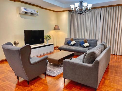 a living room with two couches and a television at NT Place Sukhumvit Suites in Bangkok