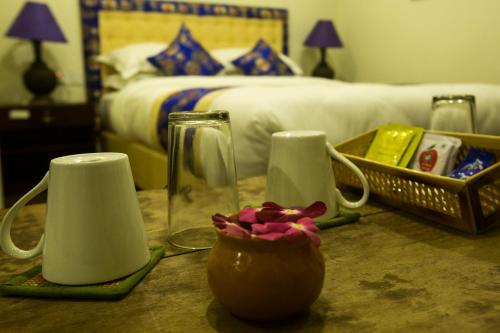 einen Tisch mit zwei Pitchers und eine Vase mit einer Blume in der Unterkunft Heranya La:Ku in Pātan