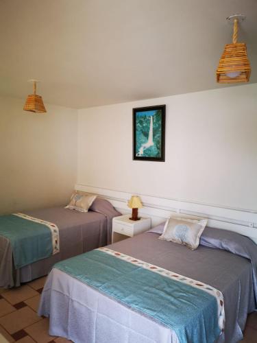 a room with two beds and a picture on the wall at Hotel Puerto Inka in Chala