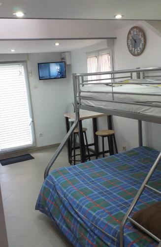- une chambre avec des lits superposés et une horloge murale dans l'établissement studio mezzanine 5 personnes, à La Roche