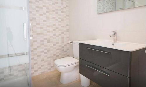 y baño con aseo, lavabo y ducha. en Verdemar Apartment with Sea View and Garden, en Nerja