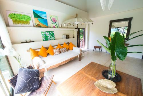 a living room with a couch and a table at Teak Hill Pool Villa-Rosewood in Ko Chang