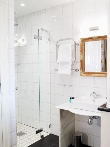 a bathroom with a sink and a shower at Hotel Kung Carl, WorldHotels Crafted in Stockholm