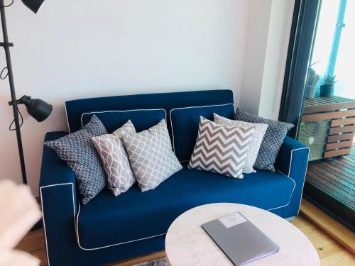 a couch with pillows and a laptop on it at Luxe Holiday Rentals in Gibraltar