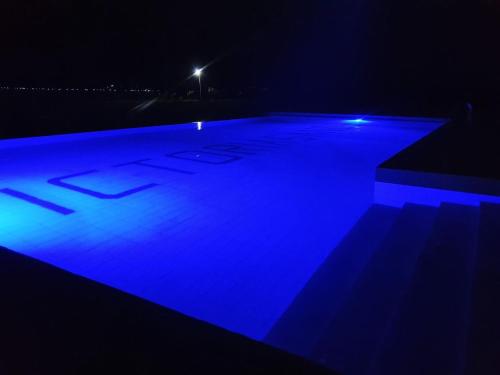 una piscina por la noche con iluminación azul en VICTORIA SANDS LODGE, en Mbita