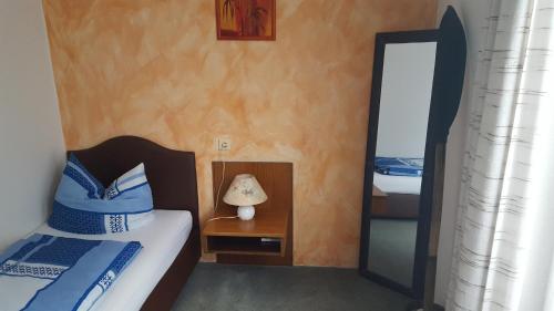 ein kleines Schlafzimmer mit 2 Betten und einem Spiegel in der Unterkunft Zimmer im Grünen in Wuppertal