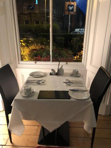 a white table with two chairs and a white table cloth at Sheridan Guest House in Edinburgh