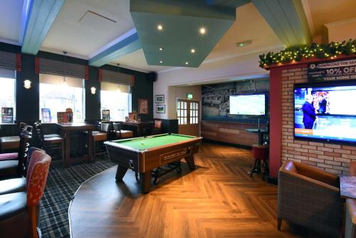 a pub with a pool table and a tv at Royal Oak by Greene King inns in Bromborough