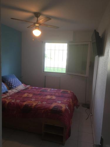 une chambre avec un lit et un ventilateur de plafond dans l'établissement T3 Les Peupliers proche Pasino et mer, à La Grande Motte