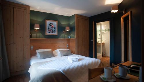 a bedroom with a large bed and a mirror at Hotel Le Monal in Sainte-Foy-Tarentaise