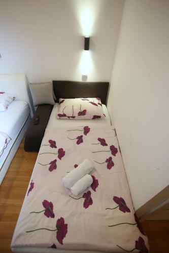 a bed in a room with flowers on it at Apartments Rooms FONTANE TRNJE - FREE PARKING in Zagreb