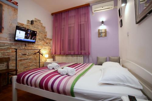 a bedroom with a bed with towels on it at Apartments Rooms FONTANE TRNJE - FREE PARKING in Zagreb