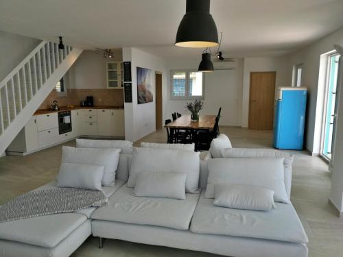a living room with a white couch and a kitchen at Sea and Wind Villa Labin in Labin