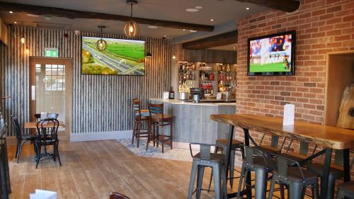 a bar in a restaurant with a tv on the wall at The Station Restaurant & Bar in Doncaster