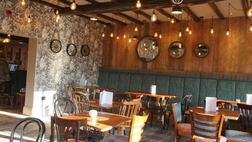 a restaurant with wooden tables and chairs in a room at The Station Restaurant & Bar in Doncaster