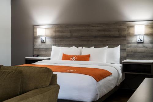 a hotel room with a large bed and a couch at Amsterdam Inn & Suites Moncton in Moncton