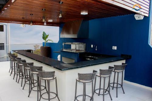 a blue kitchen with a bar with stools at Hotel Puesta del Sol in Encarnación